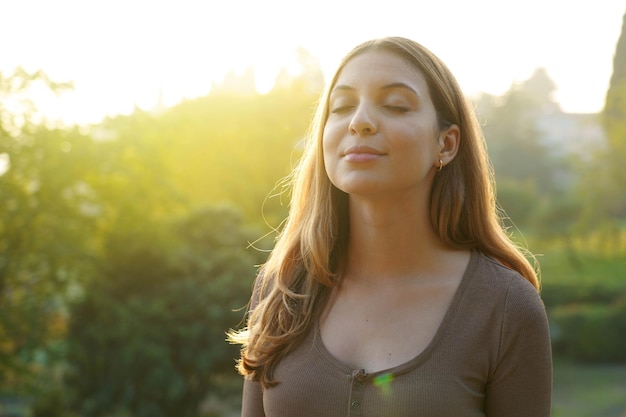 Portrait of beauty woman breathing fresh air against natural background. Copy space.