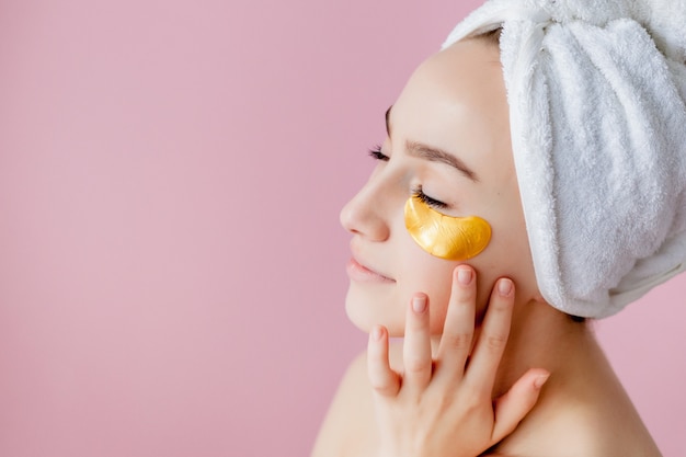 Portrait of Beauty Woman with Eye Patches on pink . Woman Beauty Face with Mask under Eyes.