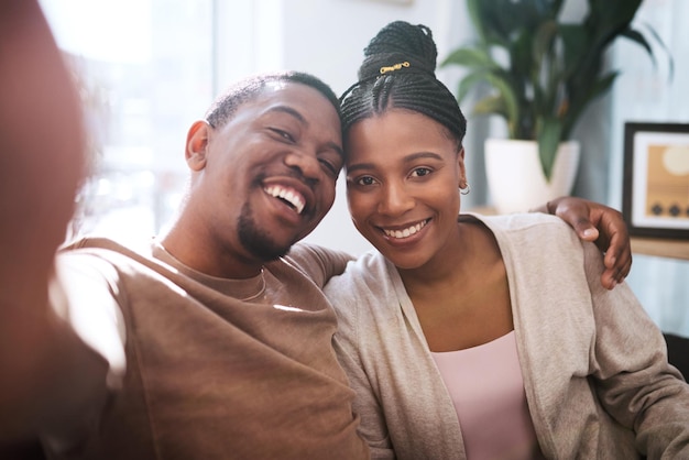 Portrait black couple and selfie in living room happy and relax while bonding embrace and smile in their home Face love and man with woman in lounge for photo enjoy their relationship