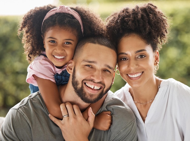 Portrait of black family mom dad and girl having fun and smiling Mother and father posing with daughter in the park or garden Family love and married couple spending time together with their kid