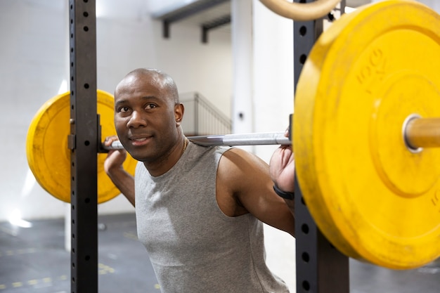 Portrait of black male athlete doing weight training in gym. Concept of health and wellness.