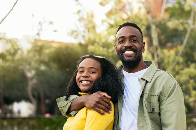 portrait of a black man hugging afro american girl