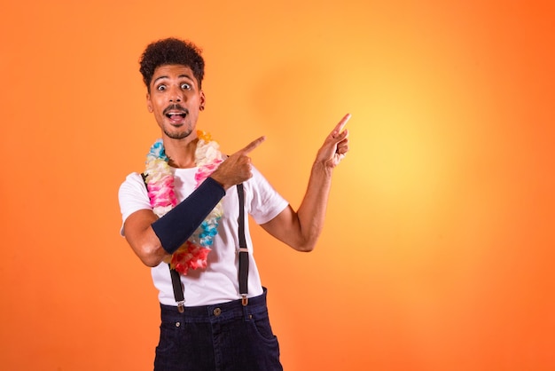 Portrait of Black Man With Carnival Props Poiting Isolated on Orange Background