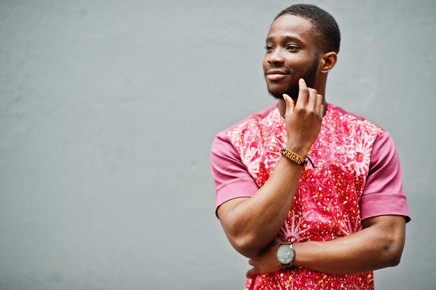 Portrait of a black young man wearing african traditional red colorful clothes.