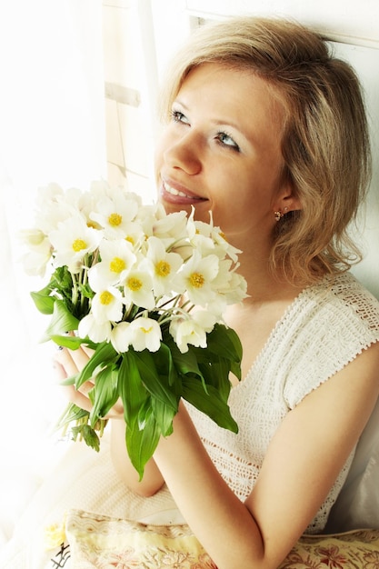 Portrait of blond woman with a bunch of hellebore