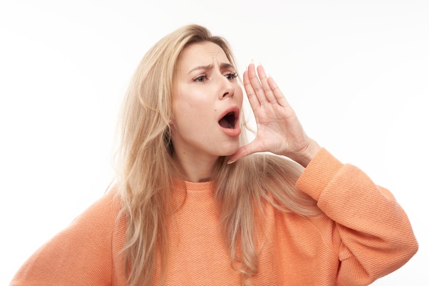 Photo portrait of blond young woman screaming into her palms on white studio background important information news conceptxa