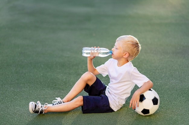 Portrait of a blonde boy in the football field