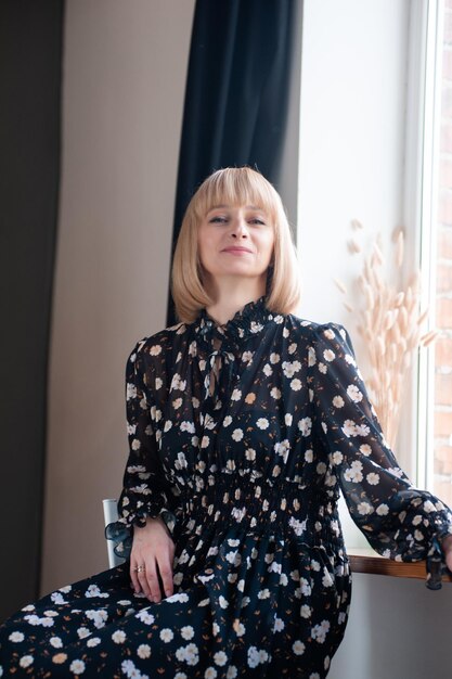 Portrait of blonde woman 35 years old in dress indoor