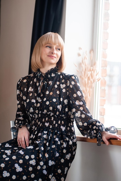 Portrait of blonde woman 35 years old in dress indoor