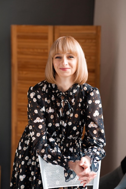 Portrait of blonde woman 35 years old in dress indoor