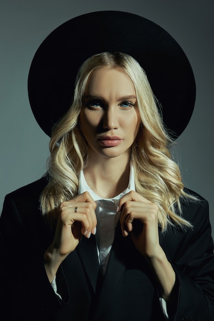 Portrait of a Blonde woman in a big round black hat