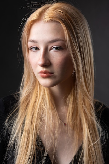 Photo portrait of a blonde woman with freckles in a sexy top and denim shorts in a studio