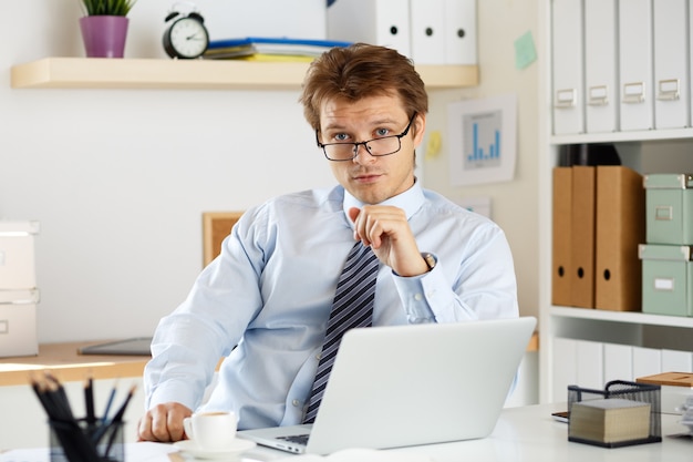 Portrait of bookkeeper or auditor sitting at his workplace. Businessman at his office.