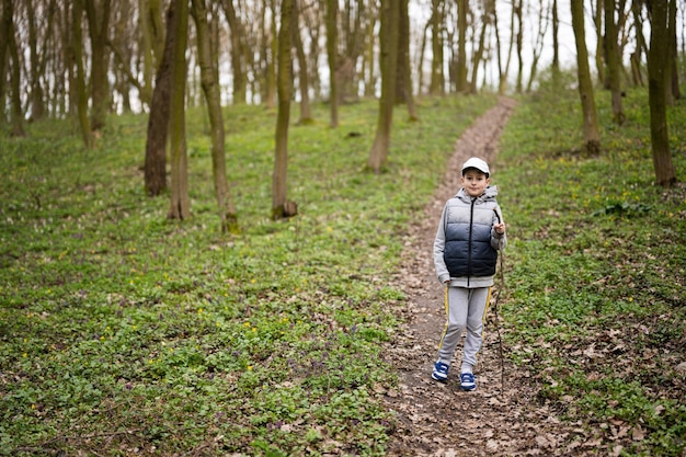 Portrait of boy in cap on forest path Outdoor spring leisure concept