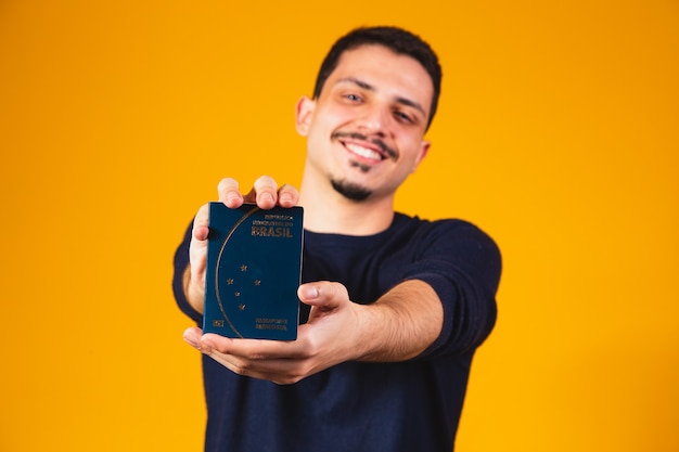 Portrait of a boy holding a Brazilian passport in his hands. Travel and migration concept