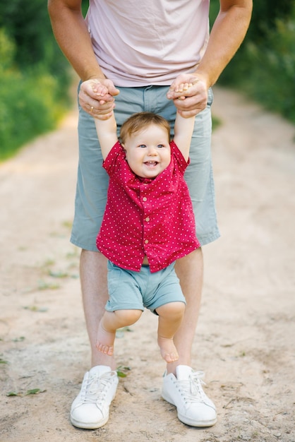 Portrait of a boy holding his father's hands