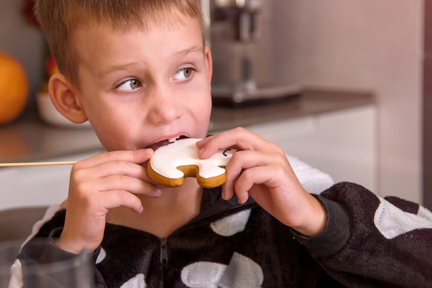 Portrait of boy in skeleton costume eating homemade cookies that look like ghost