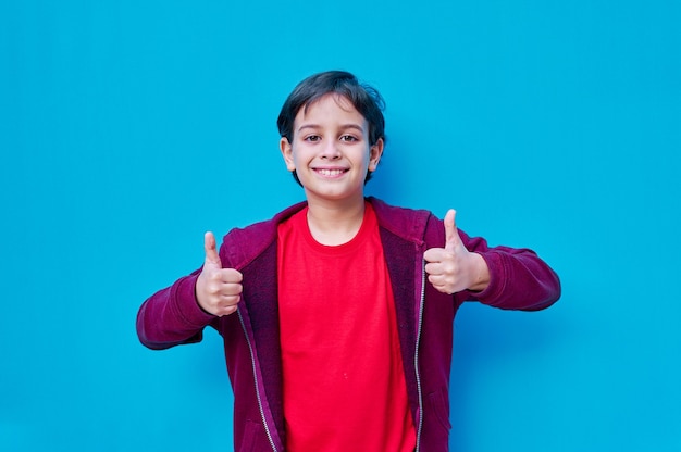 A Portrait of boy in t-shirt and jacket with thumbs of both hands up