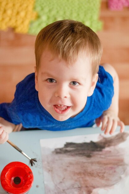 Portrait of a boy with blond hair painting a picture Early childbirth Creativity since childhood