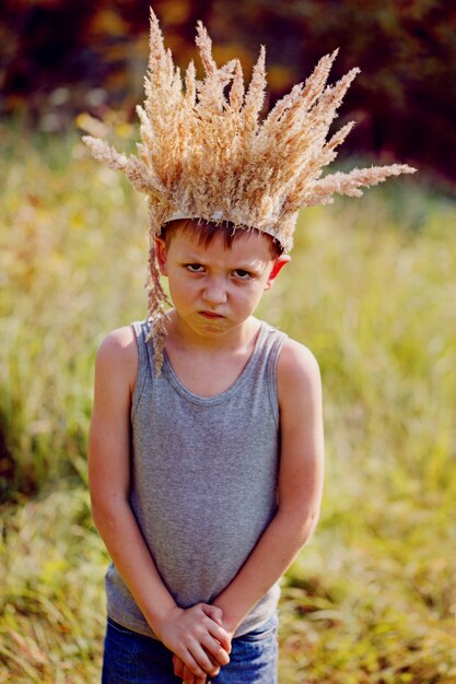 Portrait Boy with a crown on the head and a sword in hands.