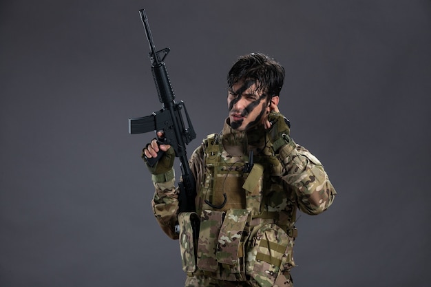 Portrait of brave soldier fighting during operation on dark wall