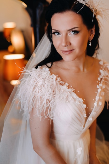 Portrait of the Bride in a wedding dress in the interior of the house near the mirror