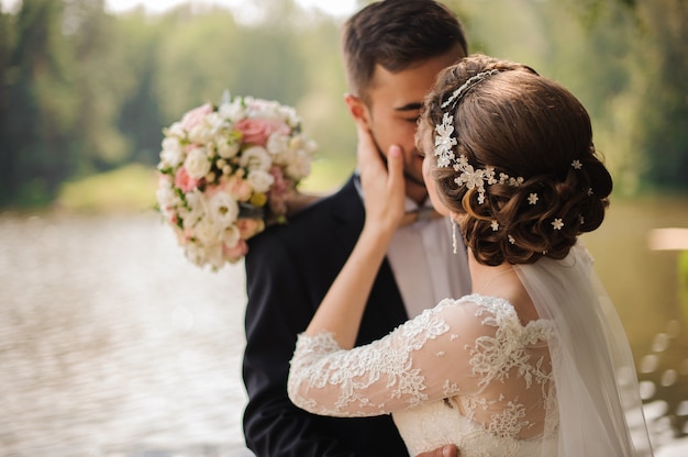 Portrait of a bridegroom kissing a bride