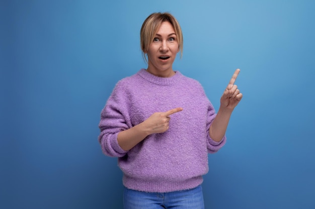 Portrait of a brilliant blonde young woman in a lilac sweater with a good thought on a bright