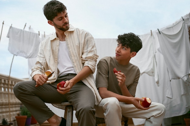 Portrait of brothers eating apples together outdoors