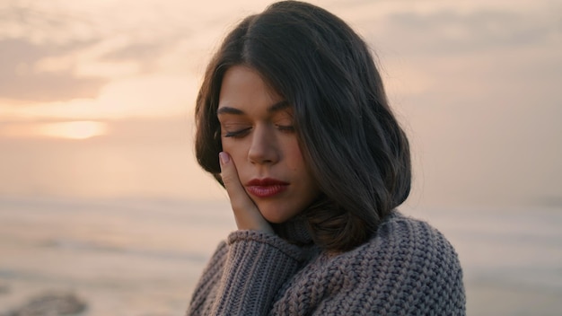 Portrait brown eyed woman in cozy sweater in front evening sky model posing