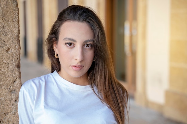 Portrait of brown hair young stylish hair style woman caucasian woman posing outdoor in the city, looking at camera