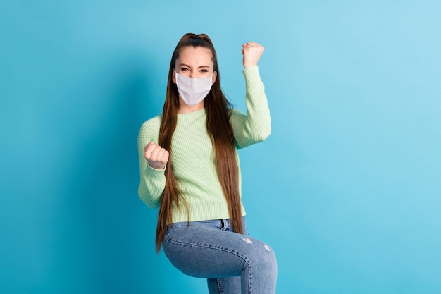 Portrait of brown-haired girl celebrate covid infection win wear medical mask isolated bright blue color background