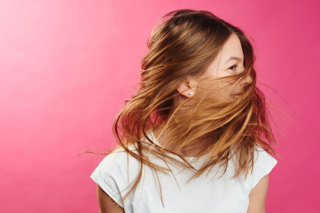 Portrait of brown-haired girl on pink background