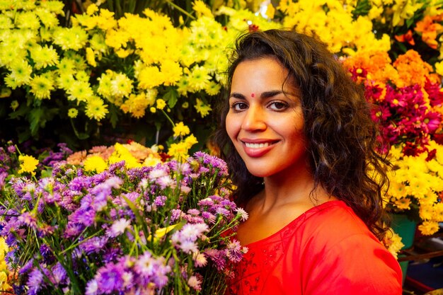 Portrait of brunette indian florist female in floral bazar looking at camera and smile