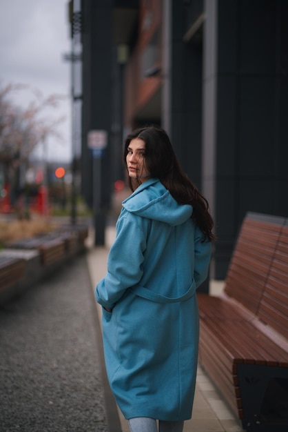 Portrait of brunette woman in the business downtown of modern city Girl with long hair turn around and looking in camera Business woman with trafic city lights in the background