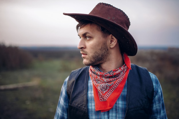 Portrait of brutal cowboy in leather jacket and hat