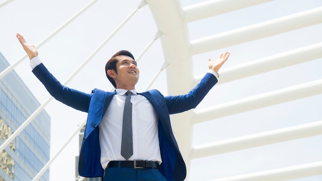 portrait of business man stand with feeling happy and freedom at outdoor city space