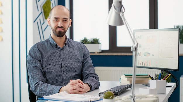 Portrait of business man working with data sales report, planning financial strategy to create company development. Male employee using charts and graphs statistics in startup office.