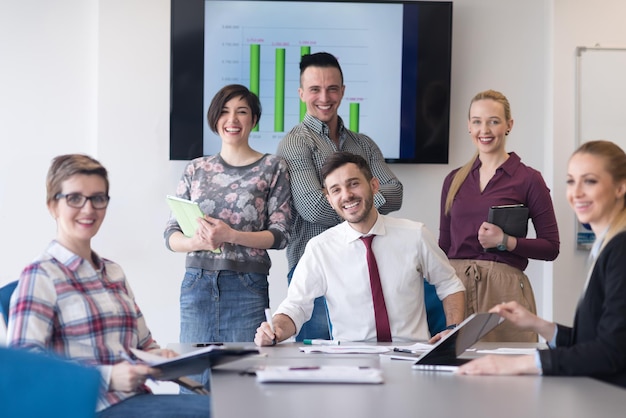 portrait of business people group at modern bright startup office meeting room, young  man with beard sitting  in middle as team leader