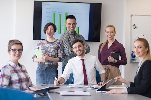 portrait of business people group at modern bright startup office meeting room, young  man with beard sitting  in middle as team leader