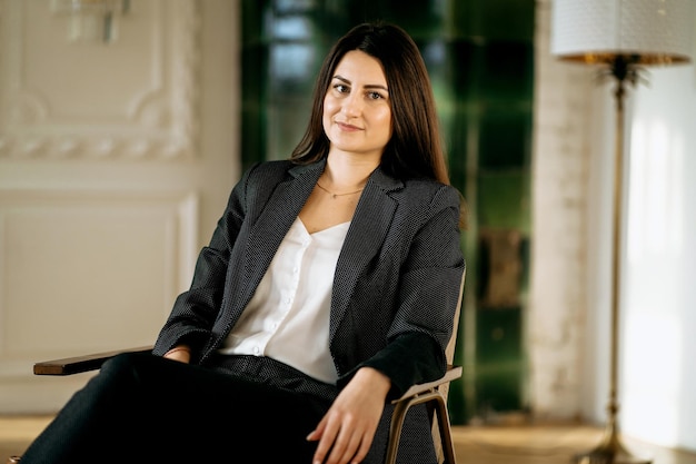 Portrait of a business woman Economist brunette Resting on a chair in a modern office