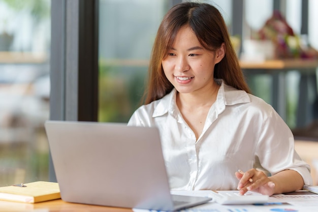 Portrait of Business woman hand using calculator to calculate the company's financial results and budget Account Audit Concept