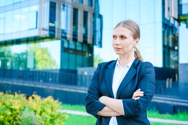 Portrait business woman smiling outdoors in business clothes against backdrop