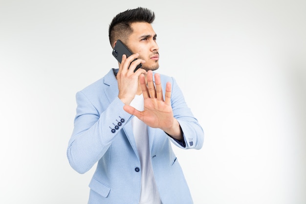 Portrait of a businessman in a blue jacket talking seriously with partners on the phone