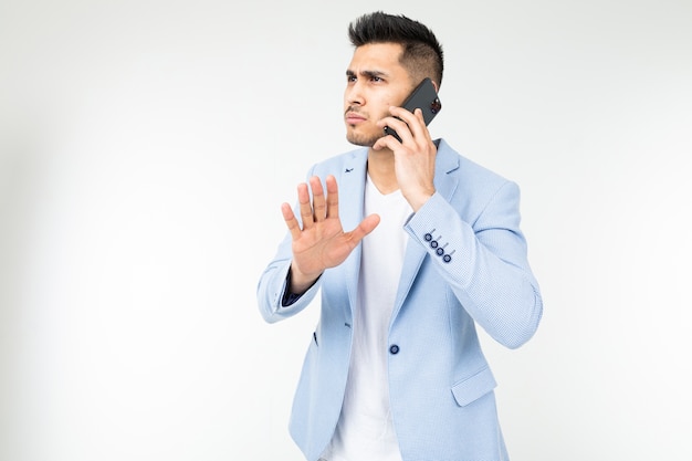 Portrait of a businessman in a blue jacket talking seriously with partners on a white background.