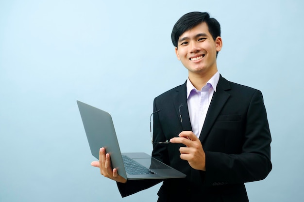 Portrait of businessman using laptop while standing