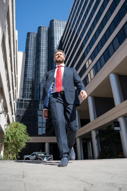 Portrait of businessman walk near office business man walking business success step boost personal c...