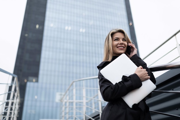 Portrait of a businesswoman against the background of a nonglass facade of an office building with a