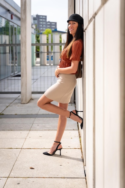 Portrait of a businesswoman outside the office leaning against a wall looking at the camera