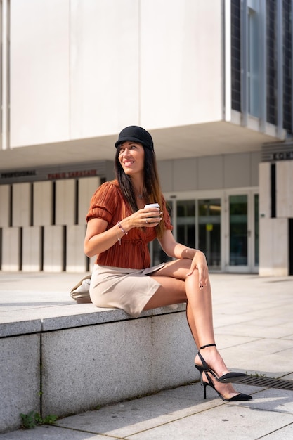 Portrait of a businesswoman outside the office with a coffee in her hand looking to the left